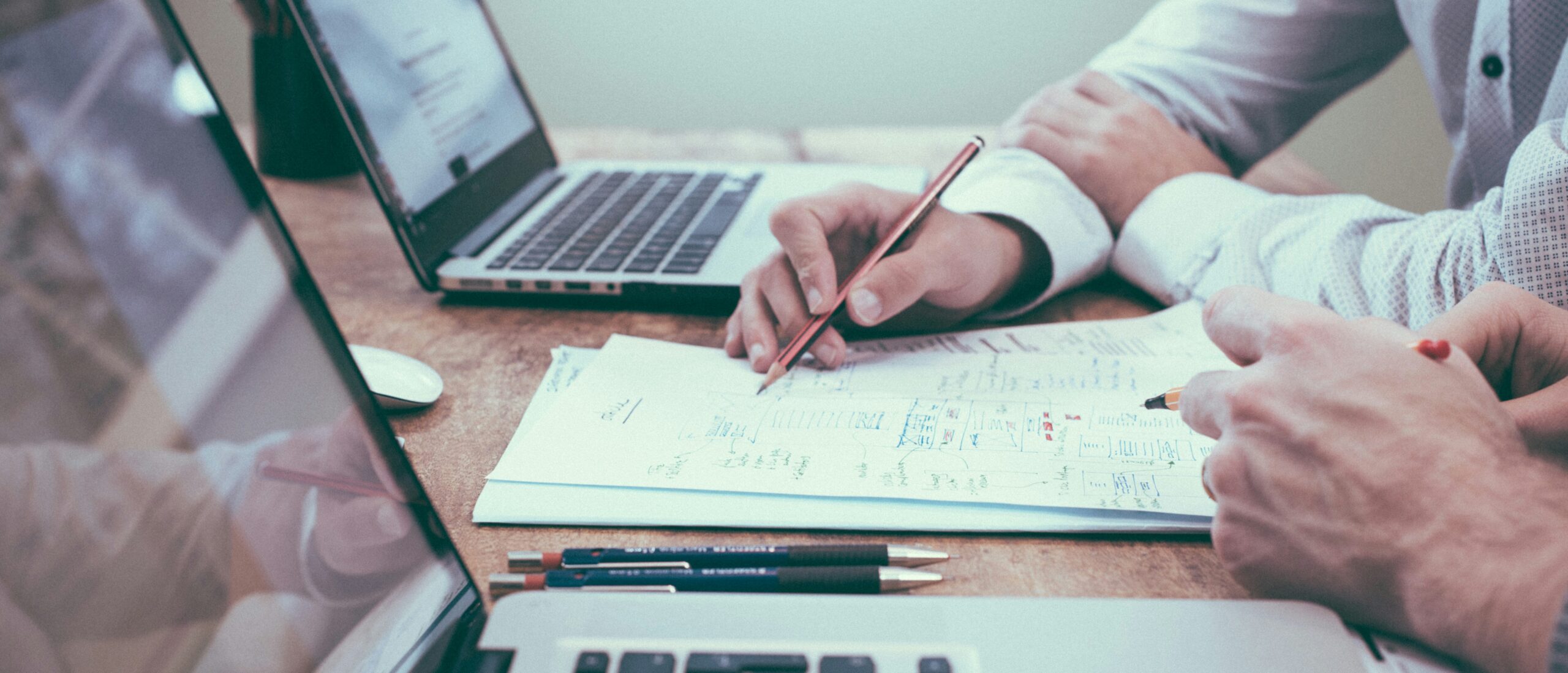 Laptop mit Notizbuch und Schweizer Franken – Symbolbild für Finanzplanung und Sparen in der Schweiz